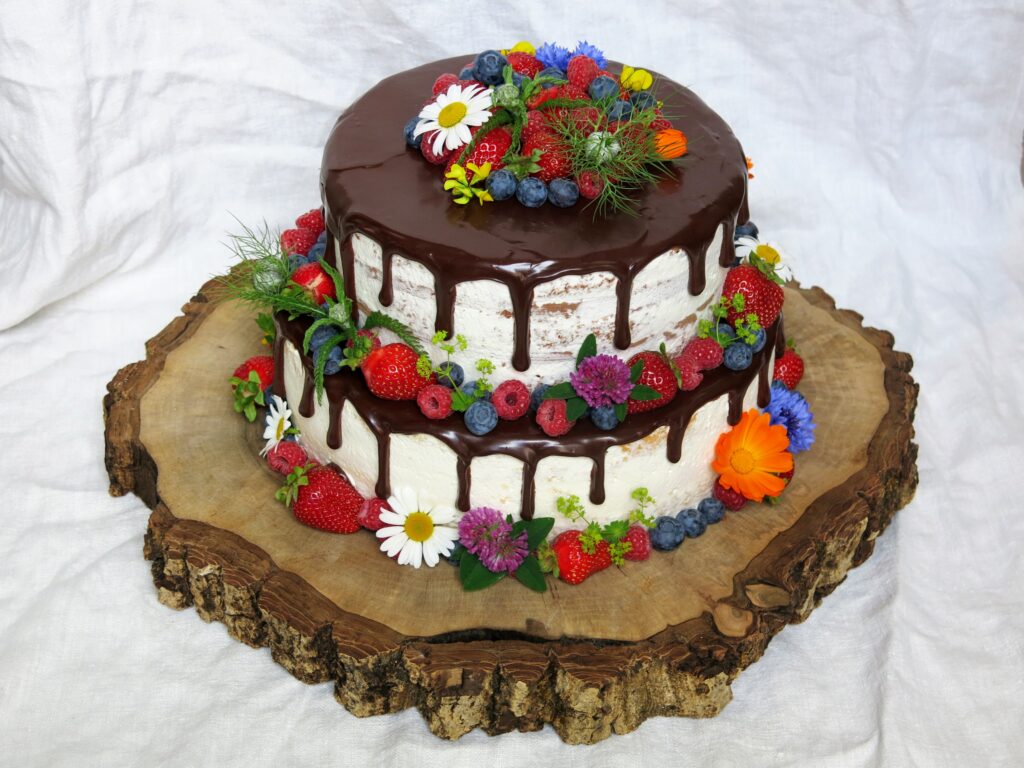 Drip Cake mit Wiesenblumen und frischen Beeren